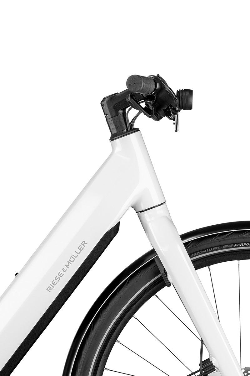 Riese & Müller UBN Six in pure white — front end detail with integrated front light and in-frame battery