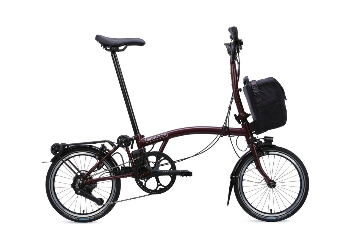 Brompton Electric C Line in plum red — full side view with front bag and rear rack