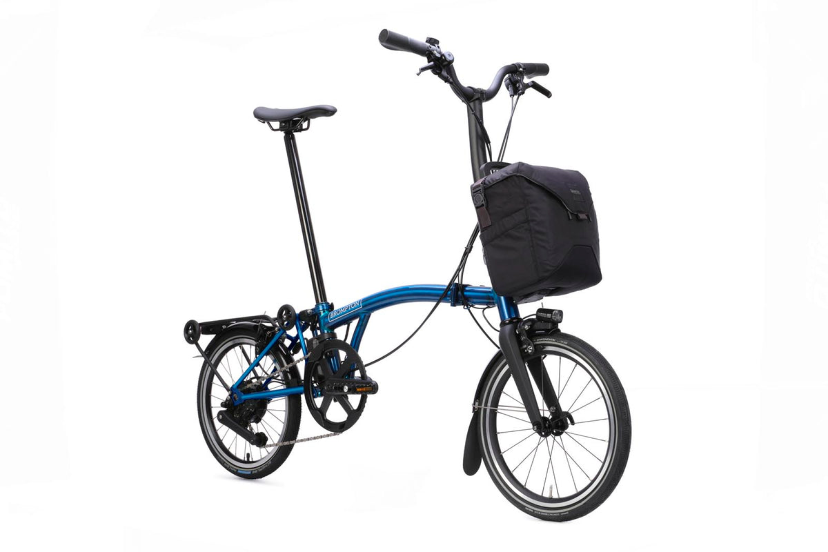 Brompton Electric P Line in pacific blue lacquer — three-quarter view with front bag