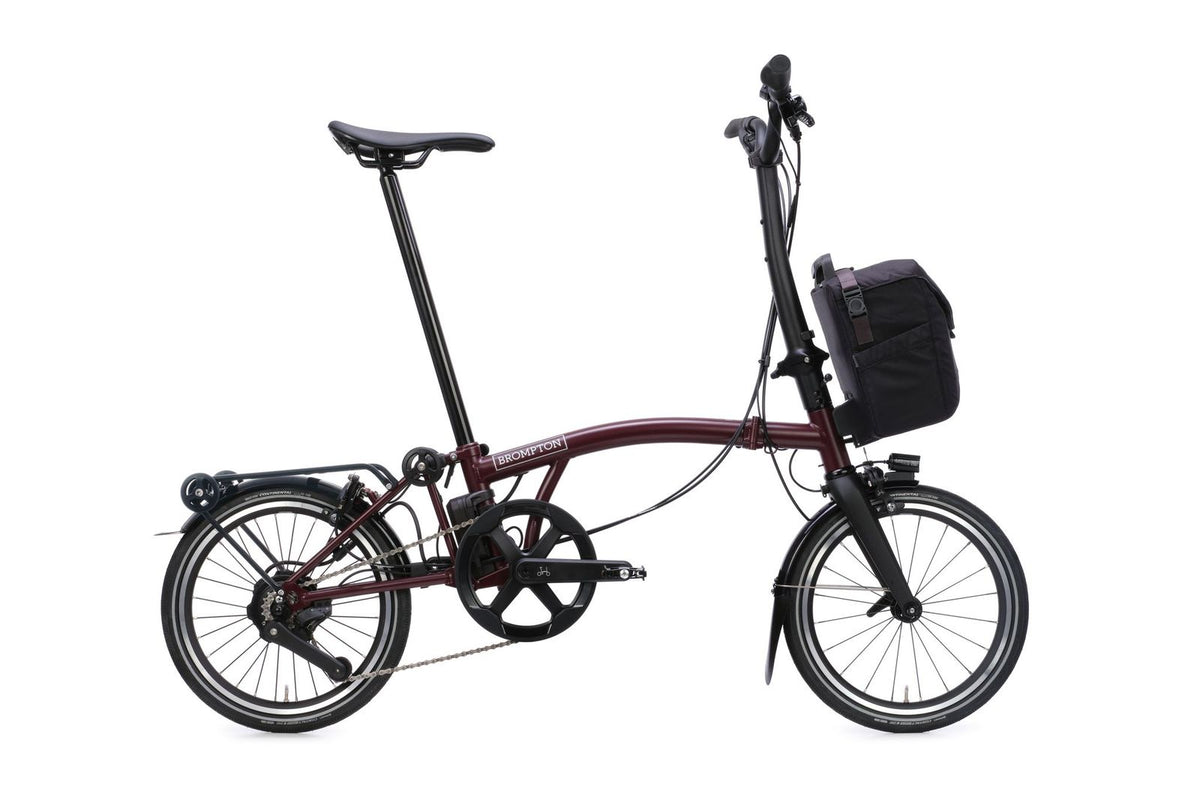 Brompton Electric P Line in plum red — full side view with front bag