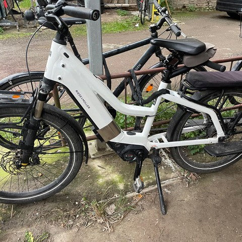 White Riese & Muller Multicharger parked outdoors with a Kattfix lock on its downtube battery