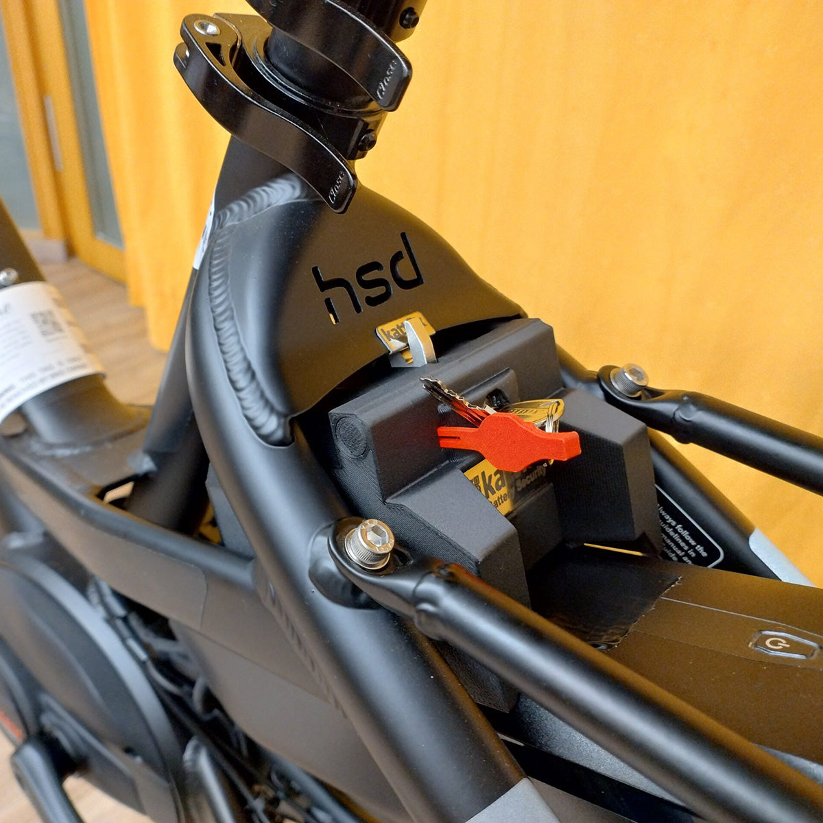 Kattfix battery lock with red key fitted behind the seat tube of a black Tern HSD
